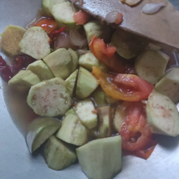 Masukkan potongan terong, lalu aduk rata.