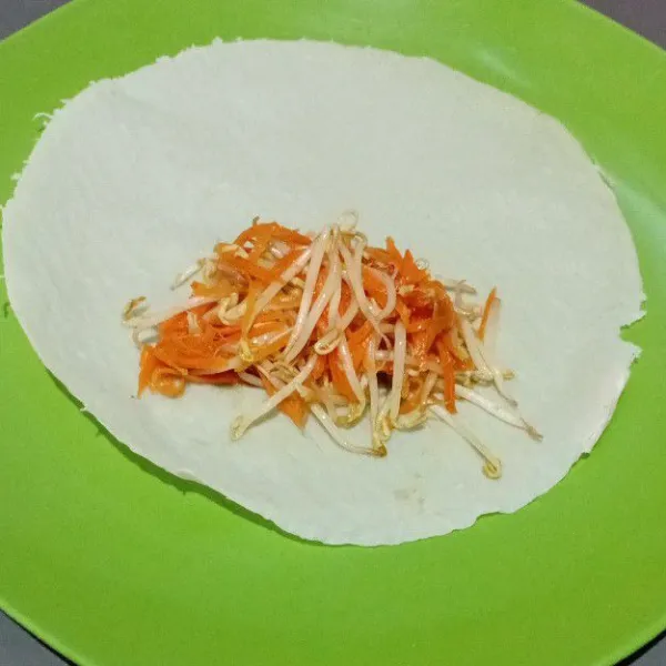 Setelah isian dingin, siapkan kulit lumpia. Beri isian, lipat dan rapikan, kemudian rekatkan dengan larutan maizena.