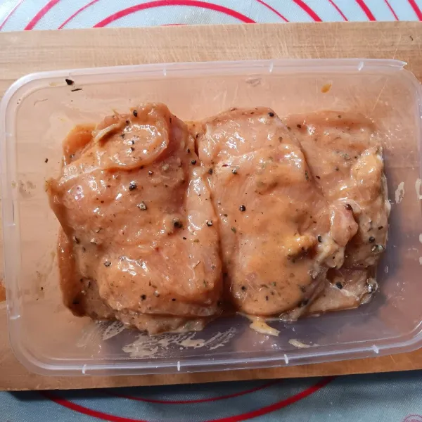 Potong ayam setebal 1-1.5 cm, pukul-pukul lalu balur dengan bumbu marinasinya. Tutup wadah dan simpan di kulkas minimal 30 menit.
