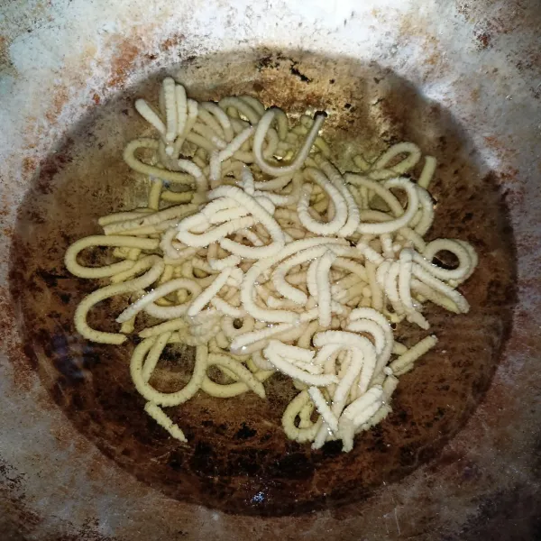 Cetak adonan di atas wajan berisi minyak goreng.