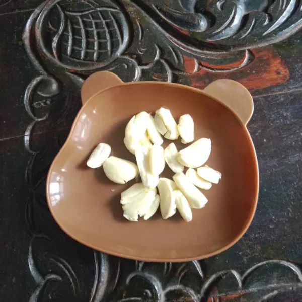 Kupas kulit bawang putih dan geprek.