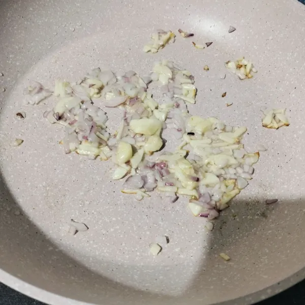 Tumis bawang merah dan bawang putih sampai layu dan harum.