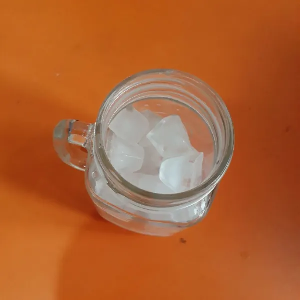 Siapkan gelas saji, isi dengan nata de coco dan es batu.