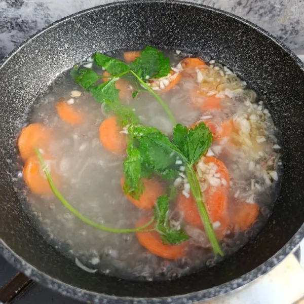 Masukkan wortel, daun seledri, dan 500 ml air. Rebus hingga wortel empuk.