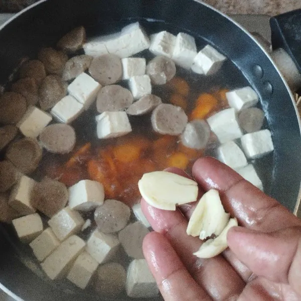 Kemudian, masukkan bawang putih geprek. Beri bumbu garam, gula, merica, dan kaldu bubuk.