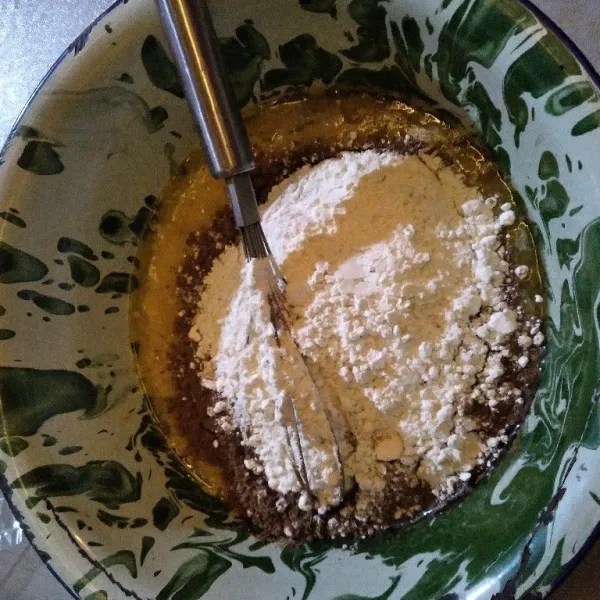 Tambahkan bahan kering sembari diayak, kemudian aduk merata.