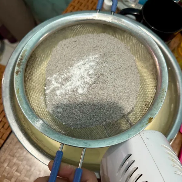 Masukkan tepung ketan dan baking powder sambil diayak, lalu aduk merata.
