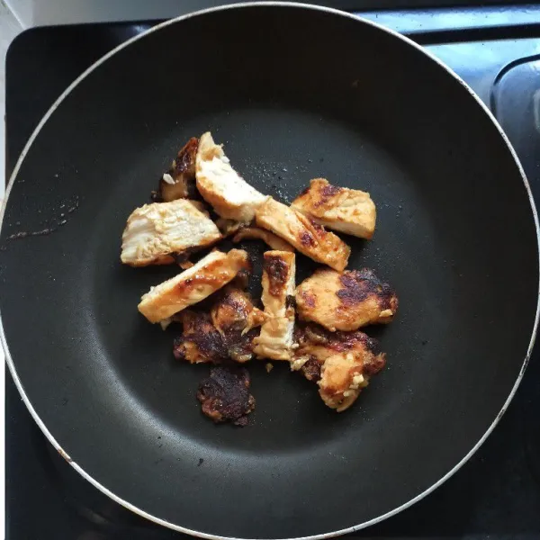 Lalu, pan seared kedua sisinya hingga kecoklatan. Kemudian, masukkan air dan potong-potong ayam sesuai selera. Masak hingga air menyusut dan ayam matang.