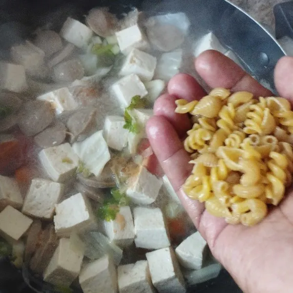Masukkan juga makaroni dan irisan tomat.