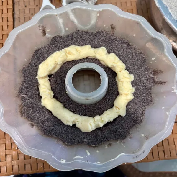 Angkat bolu, lalu buat lubang di tengah bolu, semprotkan secukupnya keju oles.