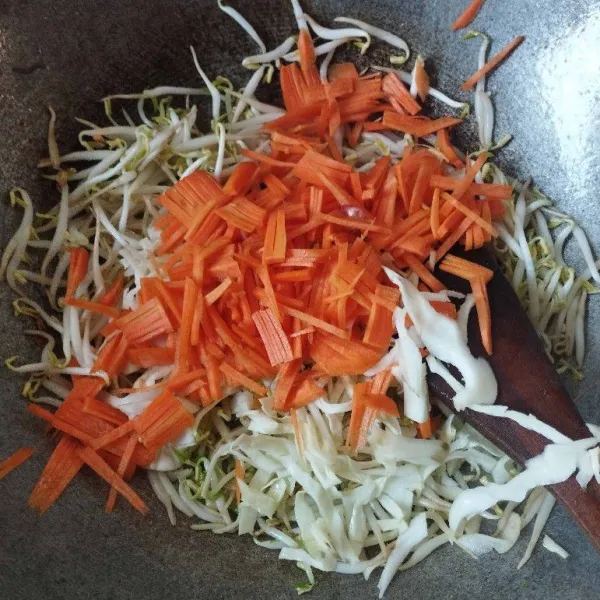 Masukkan irisan wortel dan kubis, kemudian aduk rata.