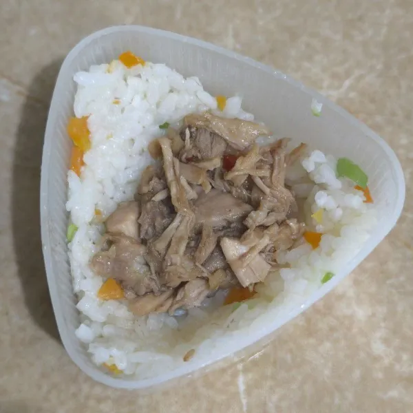 Cetak nasi dengan cetakan onigiri, beri isian ayam timpa dengan nasi lagi dan bentuk segitiga.