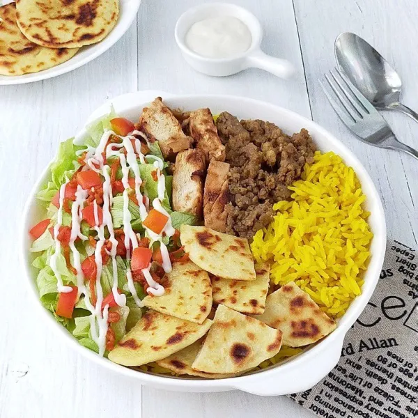 Beri toping daging ayam dan daging sapi. Sajikan dengan romaine lettuce, tomat, tortilla, white sauce, dan hot sauce sebagai pelengkap.