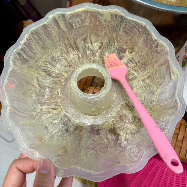 Olesi loyang dengan margarin.
