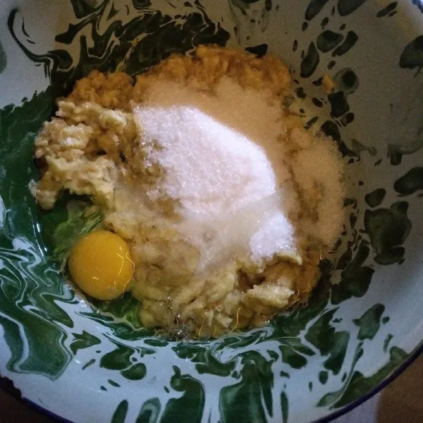 Pindahkan pisang ke wadah yang lebih besar. Tuang telur, minyak, dan gula pasir.