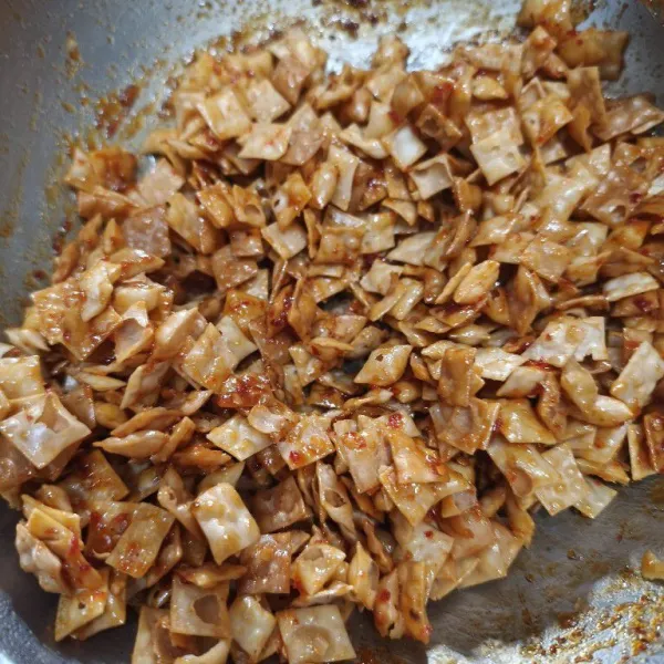 Setelah itu, matikan api. Selagi bumbu hangat, masukan kulit pangsit. Aduk sampai merata, lalu masukkan ke dalam wadah. Tunggu hingga dingin, baru ditutup.