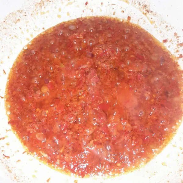 Masukkan cabe ke dalam minyak yang sudah dipanaskan, tambahkan kaldu bubuk, masak sampai bau langu hilang.