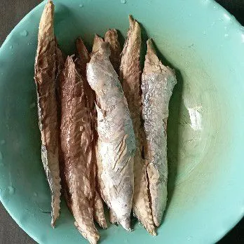 Bersihkan ikan pindang, buang kepala dan tulangnya.
