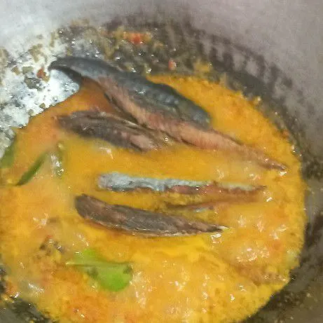 Masukkan ikan yang sudah digoreng, masak hingga air setengah menyusut.