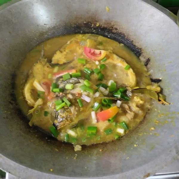 Beri irisan tomat dan daun bawang, masak hingga air menyusut.