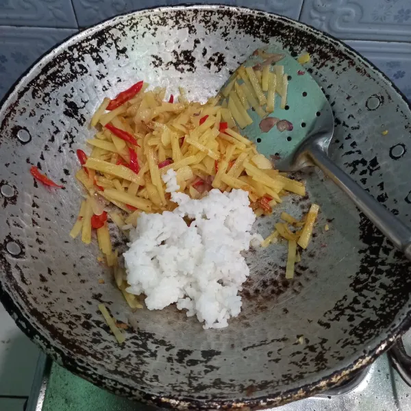 Masukkan nasi, tambahkan garam dan penyedap rasa.