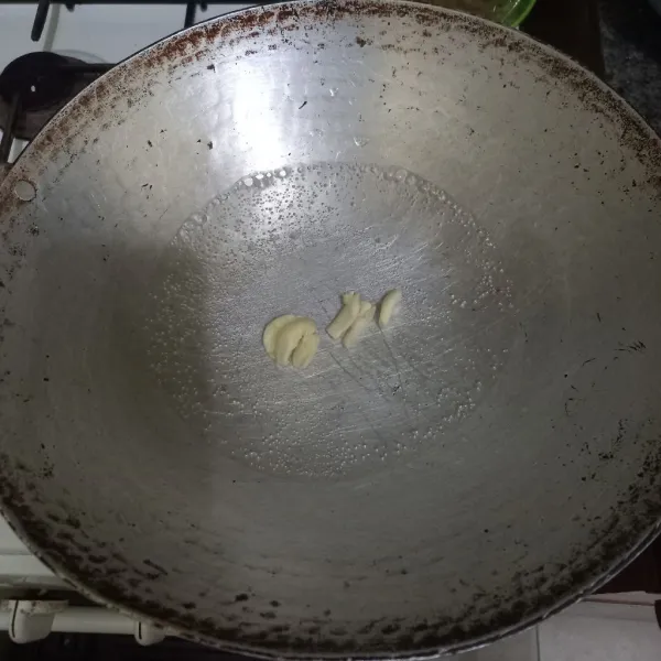 Didihkan air pada wajan, masukkan bawang putih geprek.