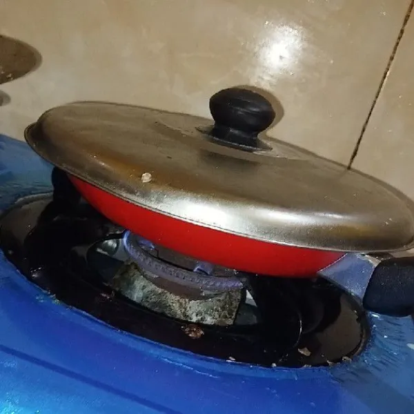 Panaskan teflon menggunakan api yang sangat kecil, lalu tutup bagian atasnya.