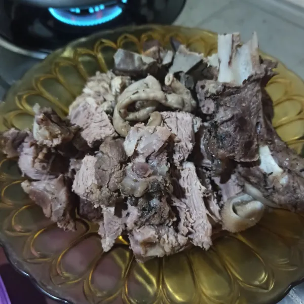 Keluarkan dari panci presto, lalu iris daging kambing.