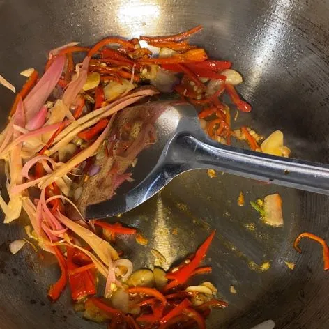 Masukkan kelopak bunga kecombrang, dan tumis hingga harum.