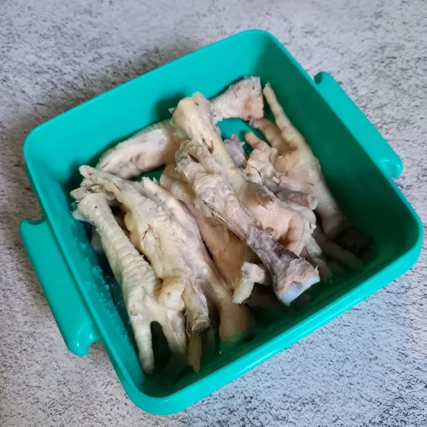Potong kuku ceker ayam. Kemudian cuci sampai bersih. Selanjutnya rebus sampai empuk dan bilas dengan air sampai bersih.