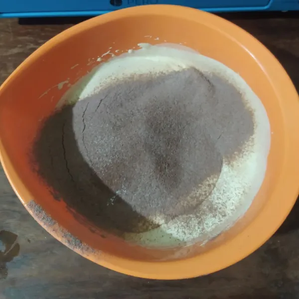 Masukkan terigu, susu bubuk dan coklat bubuk dengan cara diayak. Mikser sebentar dengan kecepatan paling rendah.
