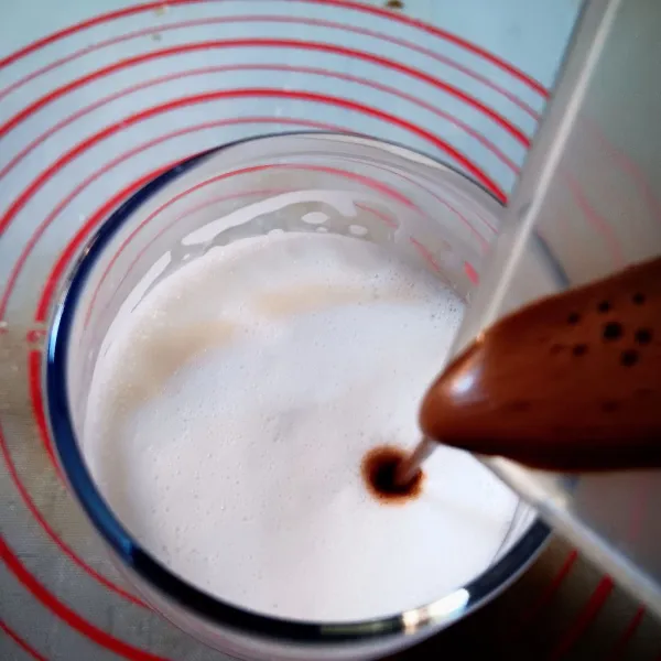 Tuang coklat kental kedalam gelas yang berisi susu secara perlahan.