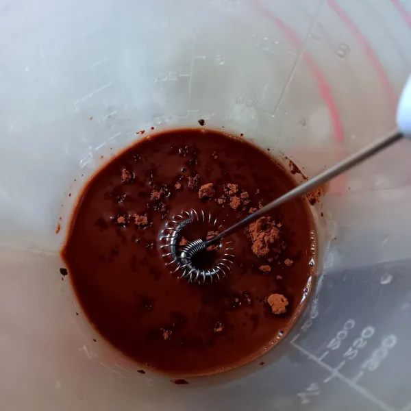 Di wadah lain, campur krimer kental manis, 1 sdm air panas dan bubuk coklat. Kocok menggunakan milk frother sampai kental.