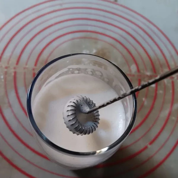 Masukkan susu full cream dalam gelas saji. Jumlah takaran susu bisa disesuaikan dengan kapasitas gelas. Kocok menggunakan milk frother sampai keluar buihnya.