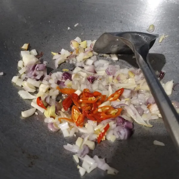 Tumis bawang rajang sampai layu dan wangi. Masukkan cabe, lalu aduk.