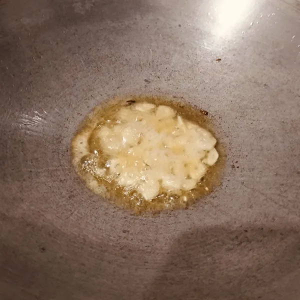 Tumis bawang putih sampai layu dan harum.