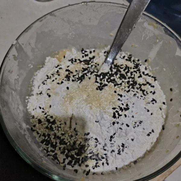 Dalam mangkok campurkan tepung terigu, tepung beras, gula, garam dan wijen.