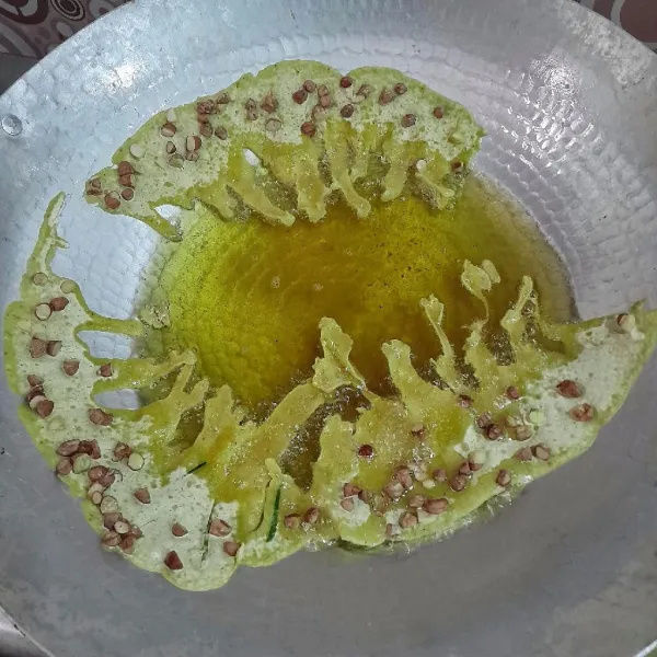 Panaskan wajan tanpa minyak dengan api sedang agar nanti rempeyeknya gampang terlepas ketika digoreng. Setelah wajan panas tuangkan minyak dan panaskan minyak sayur dengan api sedang.
Tuang 1 sendok sayur kecil adonan rempeyek dipinggir wajan dan biarkan hingga terlepas dengan sendirinya. Siram-siram permukaan rempeyek dengan minyak agar rempeyek menjadi kokoh atau ditekan-tekan pelan agar rempeyek terendam minyak. Aduk-aduk adonan setiap kali akan menggoreng rempeyek agar tidak ada tepung yang mengendap.