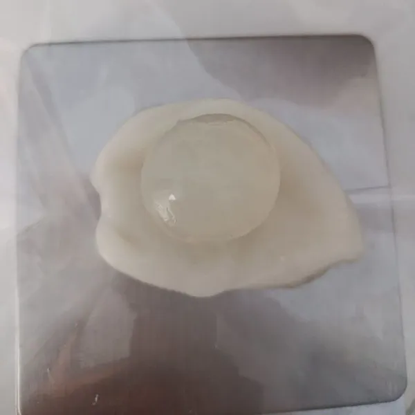 Kemudian bagi adonan sebanyak jumlah bola jelly kelapa. Pipihkan dengan bantuan plastik. Tata bola jelly ditengah kemudian tutup rapat dengan bantuan plastik.