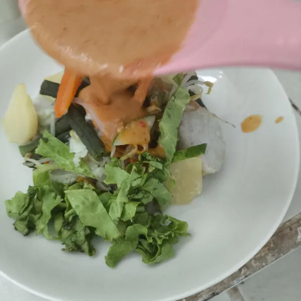 Tata kacang panjang, kubis, kecambah, kentang, telur, tahu, wortel, mentimun, selada yang telah direbus dan digoreng sebelumnya, lalu tuangkan bumbu kacang mente diatasnya dan taburi bawang goreng.