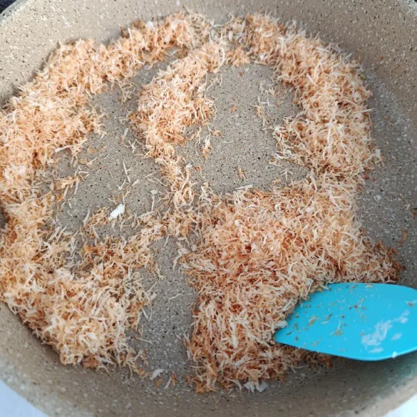 Sangrai kelapa parut hingga kecoklatan, biarkan dingin.