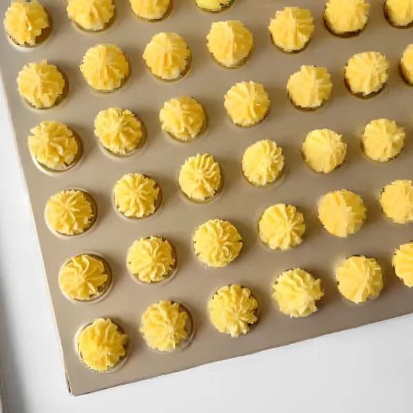 Semprotkan adonan ke atas loyang yang sudah dialasi kertas panggang. Panaskan oven terlebih dahulu pada suhu 165°C. Panggang cookies selama 25 menit hingga berwarna kuning keemasan.