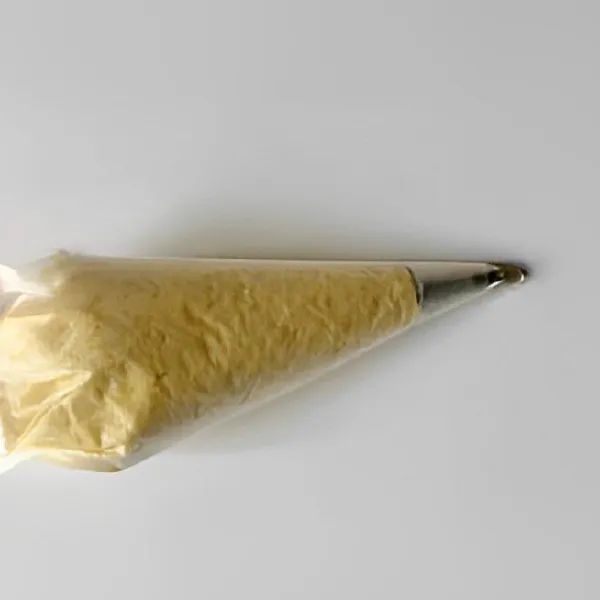 Masukkan adonan ke dalam plastik segitiga yang telah diberi spuit bintang.