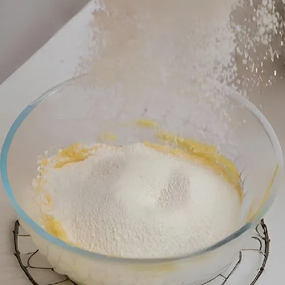 Masukkan 120 gr mentega suhu ruang ke dalam wadah besar, tambahkan 120 gr gula pasir, lalu aduk rata.