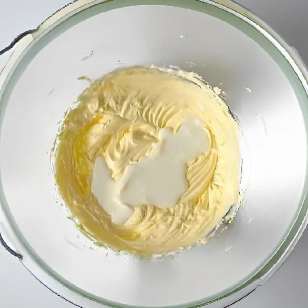 Masukkan 5 gr parutan kulit lemon, aduk hingga aroma lemon menyatu ke dalam adonan. Tambahkan 35 gr yogurt tawar, lalu aduk hingga tercampur rata dan adonan tampak halus.