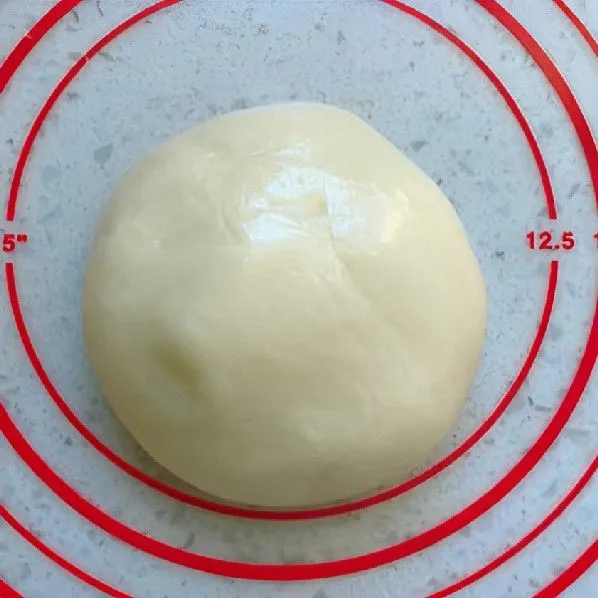 Taburkan 20 gr tepung ketan matang di atas permukaan kerja, uleni dan pipihkan adonan menjadi bentuk persegi panjang.