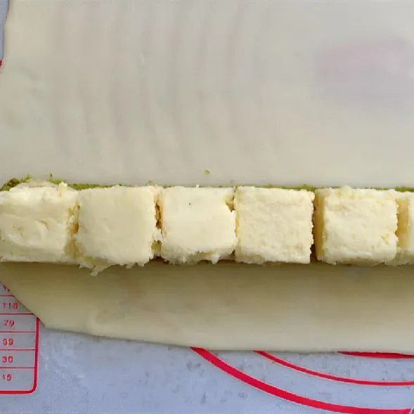 Letakkan potongan kue matcha dan semprotan krim susu di tengahnya, lalu gulung rapat. Simpan dalam kulkas dan dinginkan selama 1 jam.