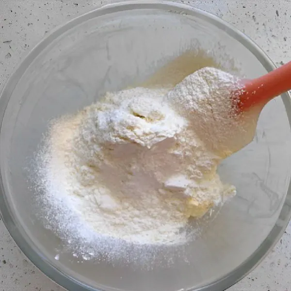 Masukkan 110 gr tepung terigu rendah protein dan 10 gr tepung jagung yang telah diayak, aduk rata hingga menjadi adonan yang lembut dan tidak lengket.