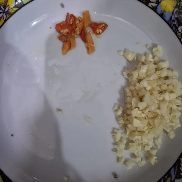 Cincang halus bawang putih dan iris-iris cabe rawit.