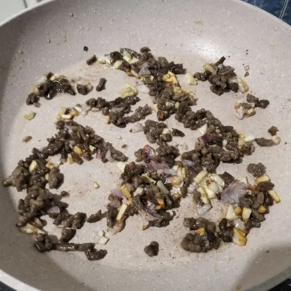 Masukkan daging giling, lalu masak kembali hingga setengah matang.